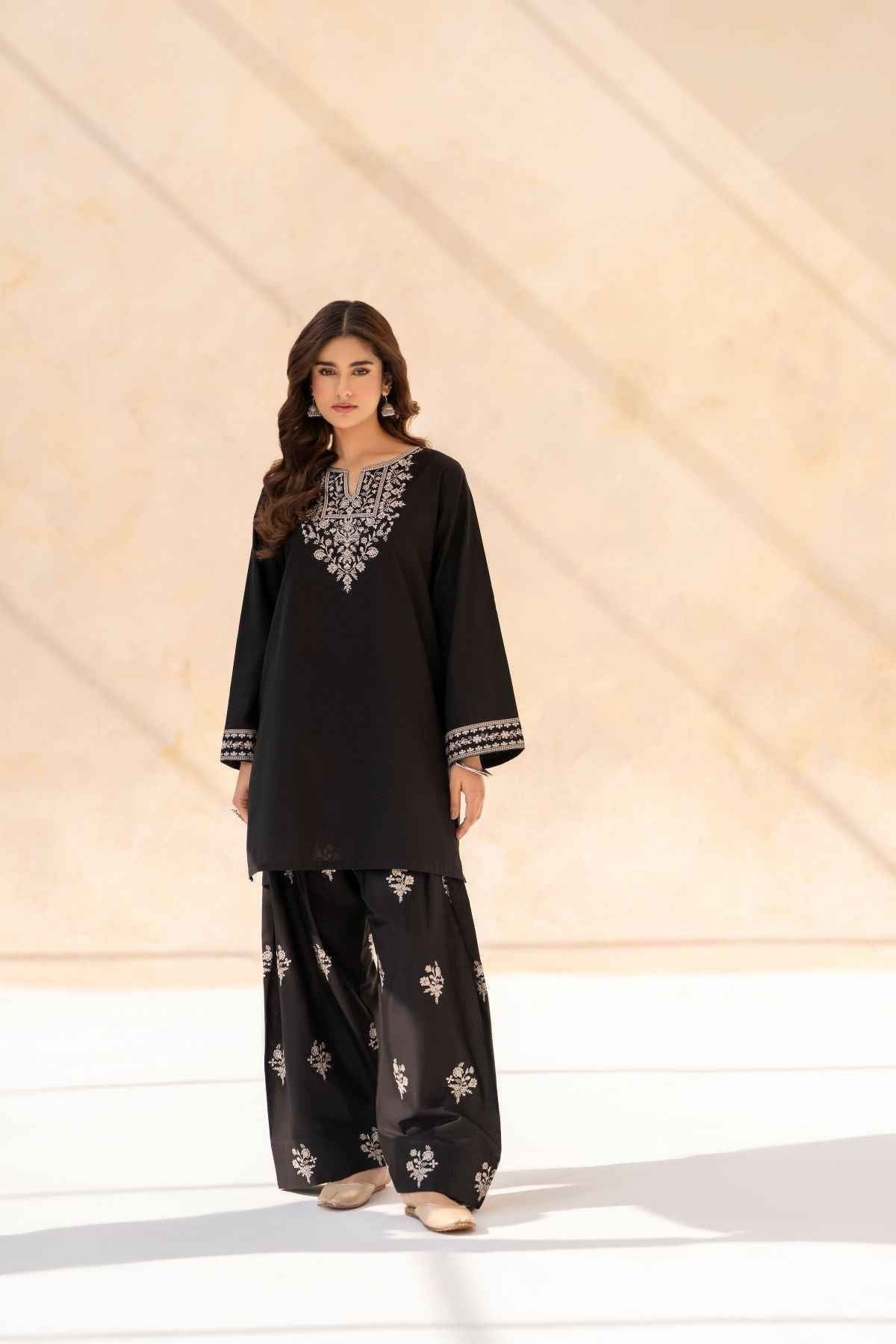 Full-length view of model wearing Cloothy Aylin black lawn suit with intricate embroidery.