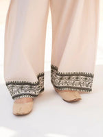 Close-up of the embroidered sleeve and hem details on the Roshni green lawn suit.